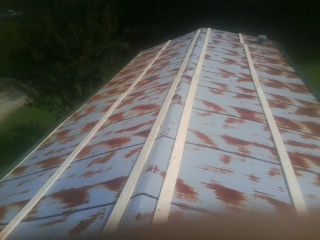 Rusted metal roof panels with new wood purlins before replacement — Storm Damage Roof Repair in Brookeville by Roofing Brothers