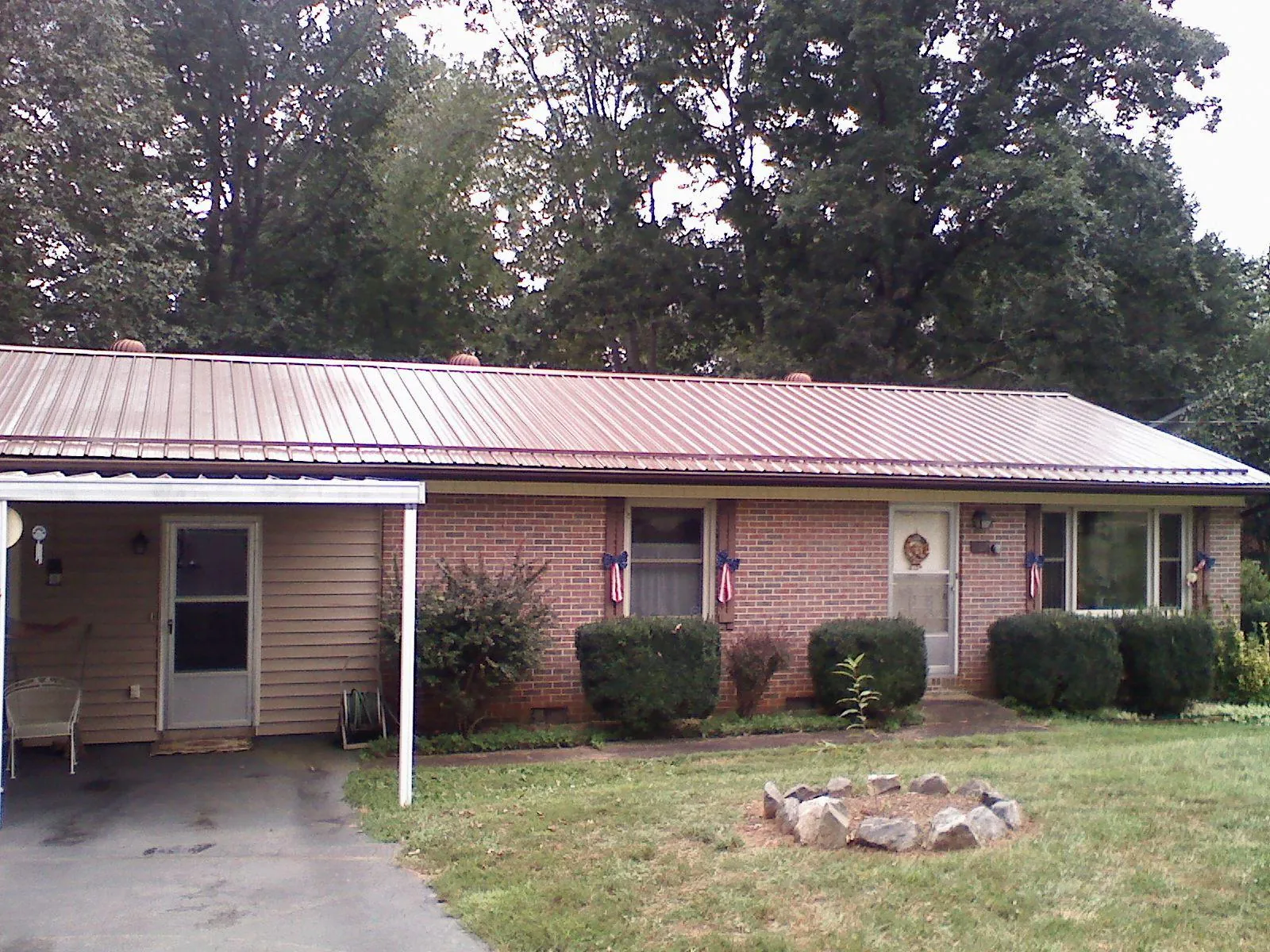 Bronze metal roof and carport on a brick ranch home — Roof Repair work by our crew in Brookeville