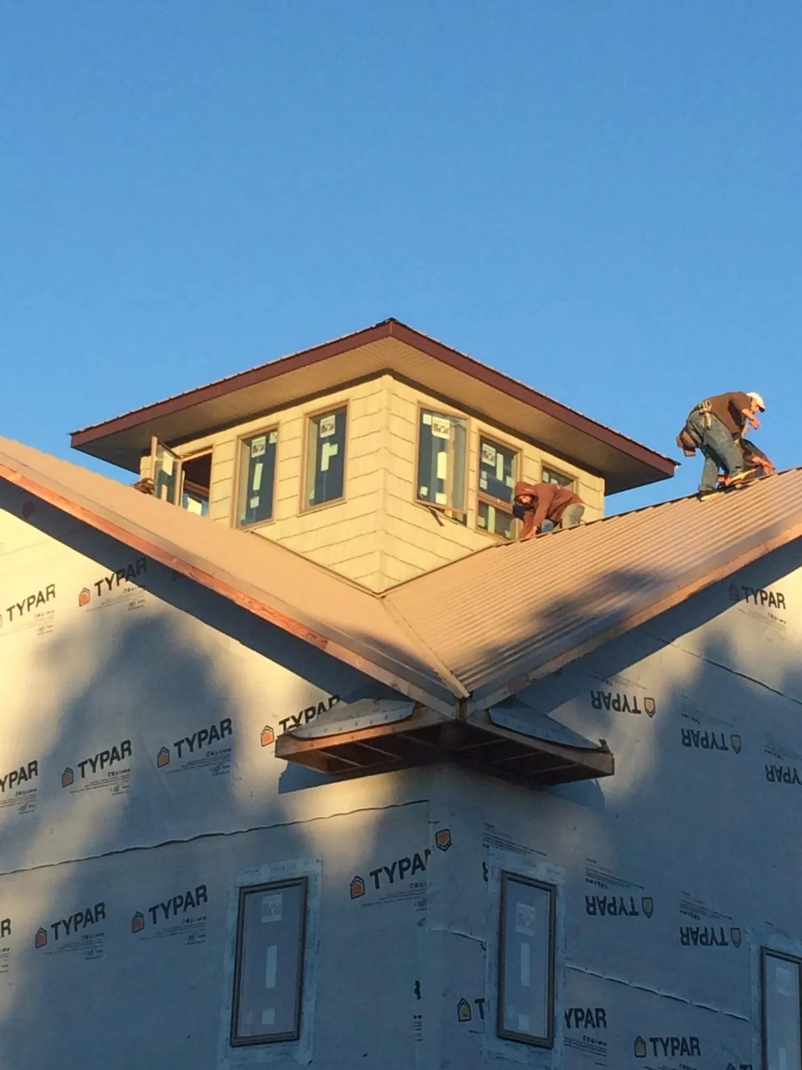 Roofers working around a rooftop cupola on a new metal roof at sunset — Roof Waterproofing in Brookeville by Roofing Brothers